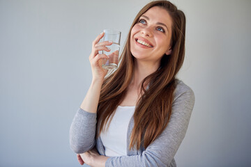 Smiling happy woman holding water glass looking away. isolated portrait casual dressed girl.