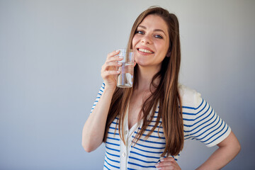 Woman in casual dress drinking water. isolated portrait of smiling girl.