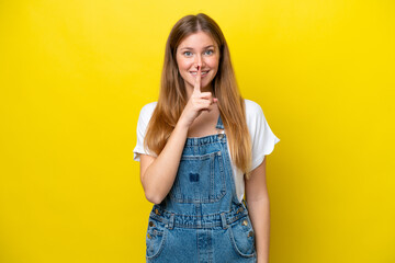 Young caucasian woman isolated on yellow background showing a sign of silence gesture putting finger in mouth