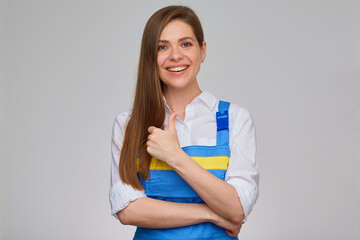 Woman in blue overalls doing thumb up. Happy girl worker isolated portrait.