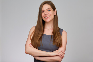 Business woman standing with crossed arms. isolated studio portrait of young woman in business dress on gray.