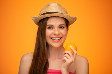 Happy smiling woman in Mexican hat with bare shoulder holding red apple, face close up girl portrait isolated over orange yellow background.