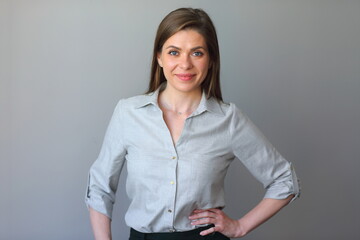 Business woman in shirt posing on gray background.