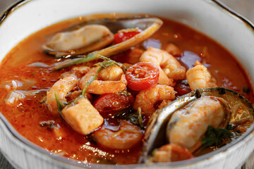 Closeup on bowl of tom yam soup with seafood
