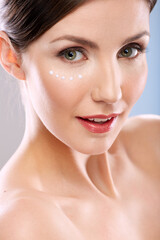 Obraz premium Woman close up portrait with cream on face. Smiling girl in beauty style head shot.