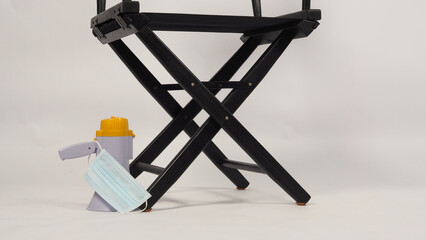 Black director chair ,face mask  put on floor with megaphone on white background.