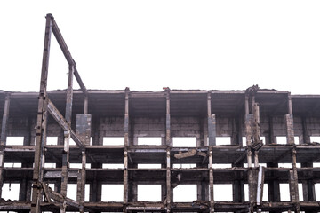 The skeleton of a large ruined building with floors without walls in a light haze isolated on a...