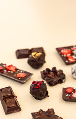 many pieces of different chocolates, handmade craft chocolate and praline broken into pieces, copy space
