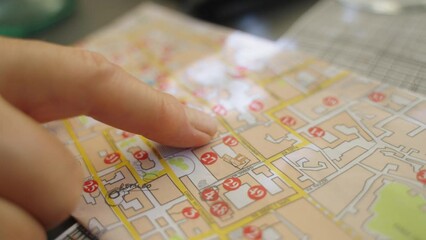 Closeup on a tourist hand pointing a touristic guide to reach some famous landmarks and museums.