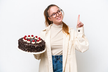 Young caucasian woman holding a Birthday cake isolated on white background pointing up a great idea