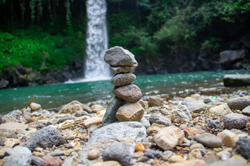 Arrangement of standing stones against waterfall background