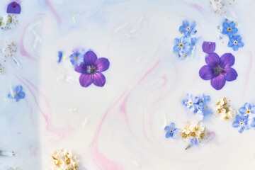Wildflowers in milky water with paint streaks. Purple and blue. Abstraction, background image....
