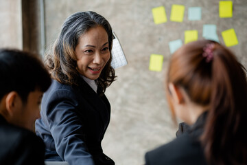 Senior businesswoman with senior executives talking in a meeting, she is meeting with department...