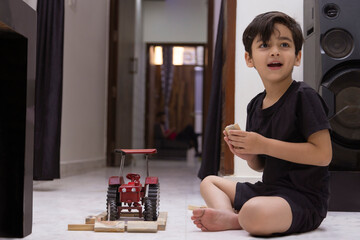 Portrait of a little boy looking away while playing with toys at home