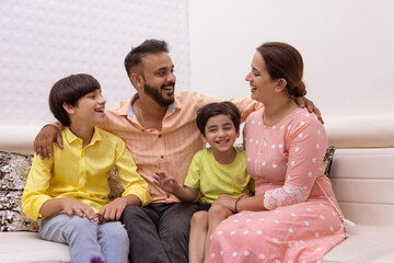 Happy family sitting together on sofa at home