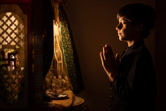 Portrait of teenage boy praying to God with folded hands