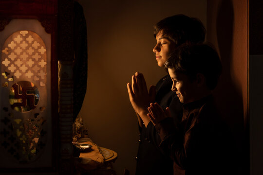 Portrait of two brothers praying together to God with folded hands