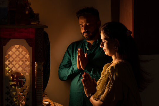 Young couple praying to God with folded hands