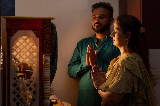 Young couple praying to God with folded hands