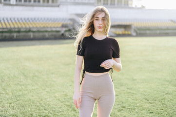 young girl stands at stadium in the evening