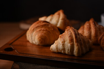 Buttery croissants on wooden board for breakfast. Levitation, bread bakery products cafe concept