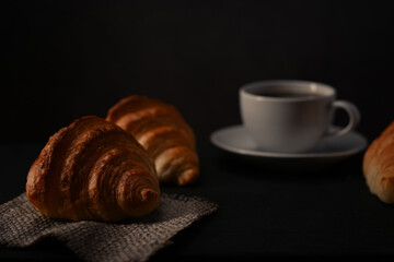 Homemade butter croissant and coffee cup on wooden table. Levitation, bread bakery products cafe concept