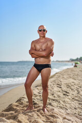 bald man on the beach by the sea on vacation