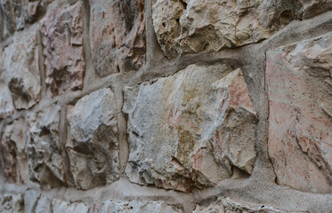 Wall of untreated natural stone. Horizontal rows stones. Perspective view.