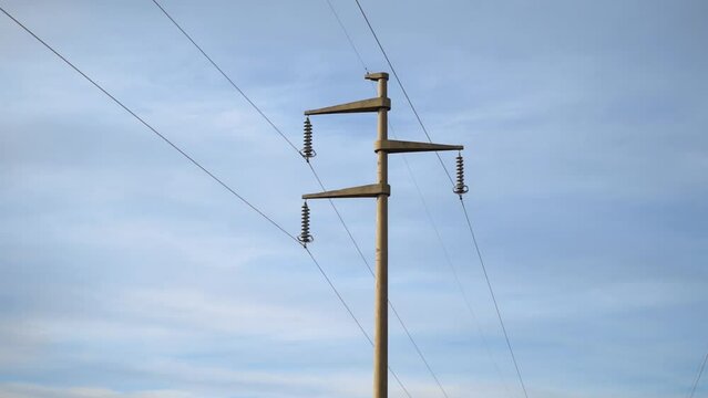 Power pole with sky in the background. Camera pan left