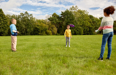 Obraz premium childhood, leisure and people concept - group of happy children playing game with flying disc at park