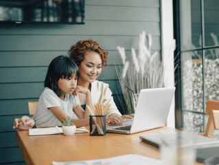 Family time, mom and girl enjoy learning on internet, helping kid study from home, work from home, having breakfast  