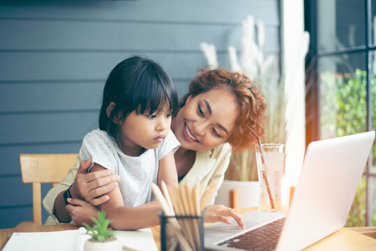 Family time, mom and girl enjoy learning on internet, helping kid study from home, work from home, having breakfast  
