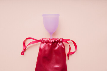 Menstrual cup with bag isolated on pink background, woman menstruation cycle concept