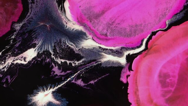Pink paint on black background creating abstract video art background. Fluid art drawing, abstract texture with colorful waves.