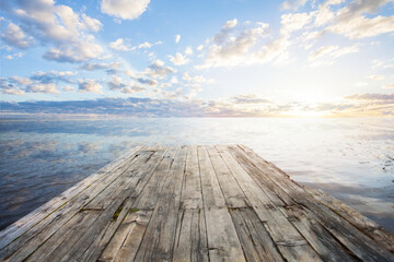 Empty wooden jetty at sunset, looking out over water