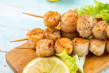 Seafood skewers, scallops cooked on the grill close-up.