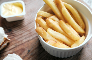 french fries close-up with cheese sauce on a wooden background, top view. Food delivery