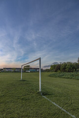 Rural soccer field in the light of the sunset, View of empty soccer goals, goals without nets, can be used as a background, background for graphic designers