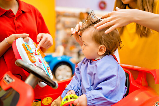 Baby's first haircut. Cute little boy at the professional children's hairdresser.