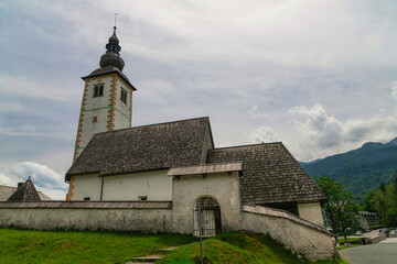 Fototapeta na wymiar Bohinj Lake, Church of St John the Baptist with bridge. Triglav National Park, Julian Alps, Slovenia.