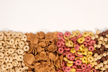 A set of different quick breakfast cereals - rings and balls, top view on white.