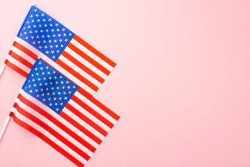 Fototapeta premium USA Independence Day concept. Top view photo of two national flags on isolated pastel pink background with copyspace