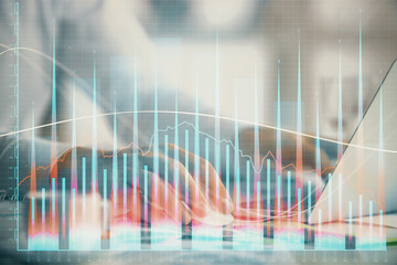 Double exposure of forex graph with man working on computer on background. Concept of market...