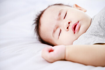 baby sleeping on the bed in the home during the daytime, Close-up shot