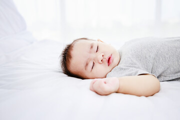 Fototapeta na wymiar Sleeping cute baby girl on bed. Protection of children.