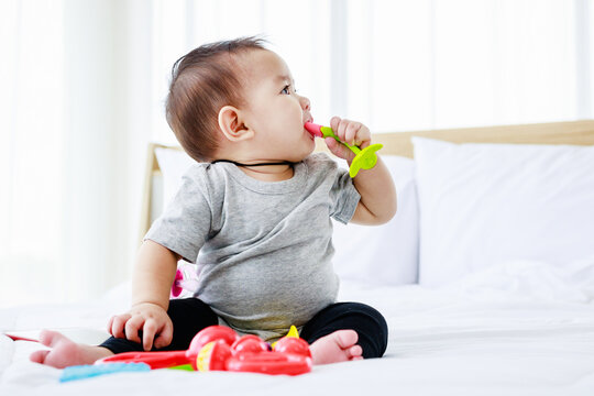 pretty baby play baby toy on bed. 8 months happy baby. development in baby concept.