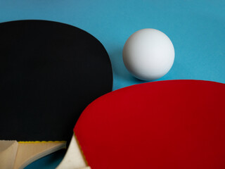 Detail of pingpong rackets and ball isolated on light blue background. Equipment for playing table tennis.