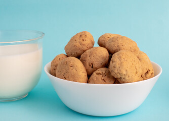 Homemade oatmeal cookies on a white plate on a blue background. The concept of healthy eating and cooking cookies. High-quality photo