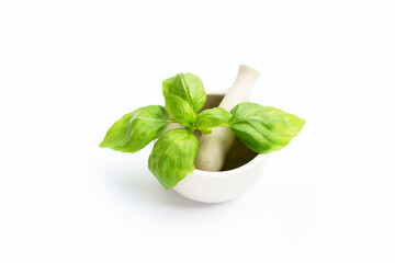 Basil leaves in mortar on white background.