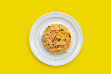 Fried rice in white plate on yellow background.
